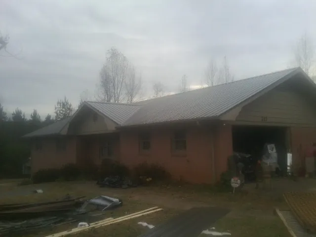Gray metal roof on a stucco house with an attached garage in Monroe