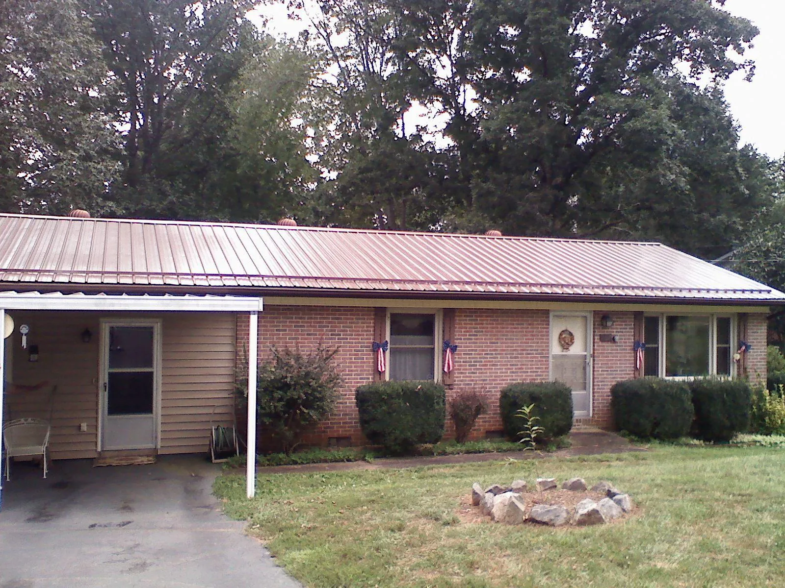 Bronze metal roof and carport on a brick ranch home — Roof Repair work by our crew in Monroe